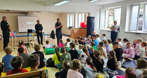 uczniowie słuchają prelekcji policjanta i strażników miejskich