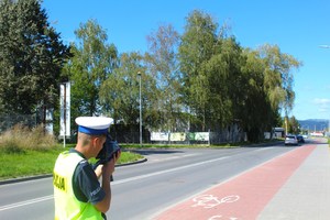 policjant drogówki z laserowym miernikiem prędkości