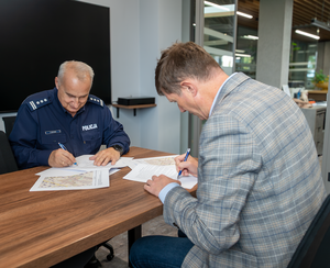 komendant i rektor podpisują dokumenty przy biurku, fot. WSB-NLU