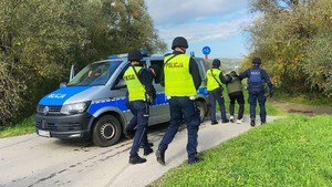 policjanci prowadzą zatrzymanego