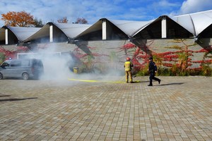strażak i biegnący policjant, z budynku obok wydobywają się kłęby dymu