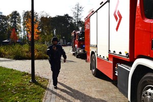 policjant przechodzący obok wozu strażackiego