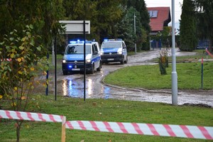 dwa jadące oznakowane radiowozy Policji