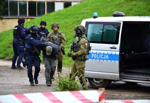 policjanci prowadzą zatrzymanych