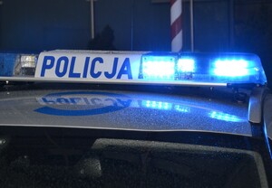 noc, fragment dachu radiowozu z włączoną lampą błyskową