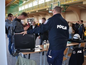 dwóch młodych mężczyzn korzysta z alkogogli zgodnie z instrukcjami policjanta