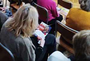 seniorka z ulotką w dłoni