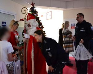 policjanci i św. Mikołaj wręczają podarunki