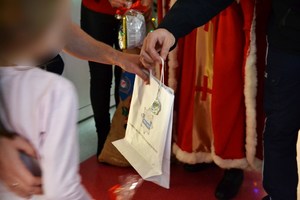 policjant wręcza torebkę prezentową dziewczynce