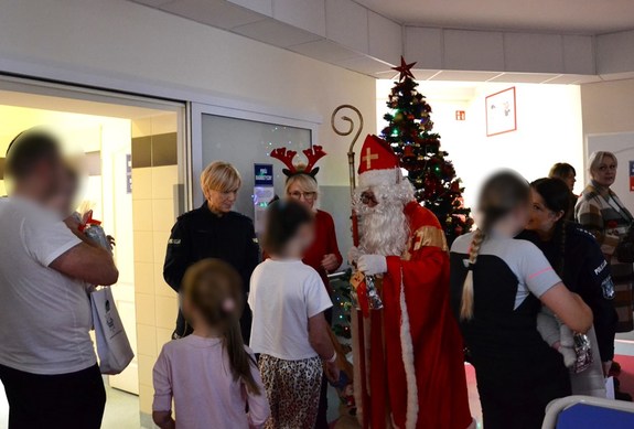 policyjna drużyna św. Mikołaja wręcza dzieciom upominki z okazji mikołajek