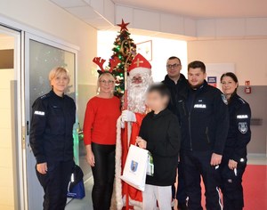 wspólne zdjęcie małego pacjenta i policyjnej ekipy św. Mikołaja