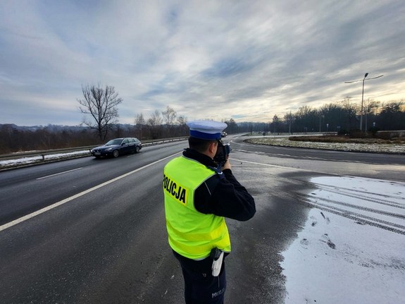 policjant ruchu drogowego z laserowym miernikiem prędkości