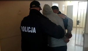 policjanci prowadzą zatrzymanego mężczyznę