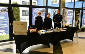 dwie policjantki i policjant stoją przy stanowisku profilaktyczno-edukacyjnym