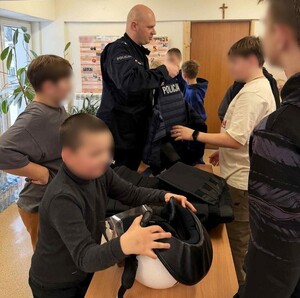 policjant prezentuje uczestnikom spotkania sprzęt służbowy — kopia