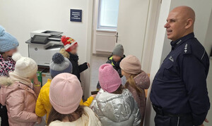 Komendant Komisariatu Policji w Nawojowej oraz dzieci uczestniczące w prelekcji o bezpieczeństwie