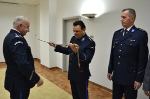 odchodzący ze służby oficer Policji z szablą w dłoniach