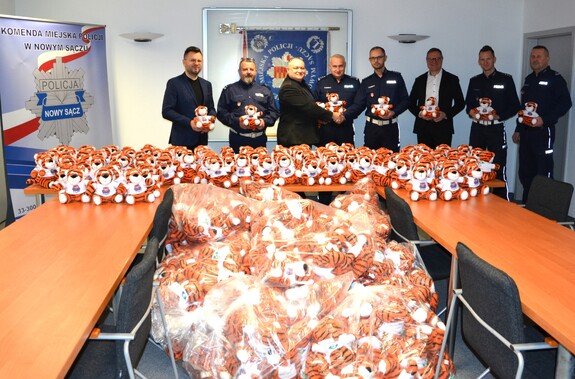 wspólne zdjęcie uczestników spotkania, pluszaki na stole i foliowych workach