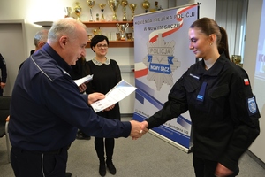 6. uczennica odbiera akt nominacyjny z rąk szefa sądeckich policjantów