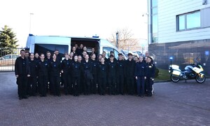 12. wspólne zdjęcie uczniów przy radiowozie, obok motocykl