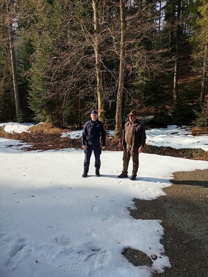 wspólne zdjęcie dzielnicowego i leśniczego w terenie leśnym