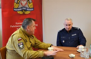 od lewej Komendant Miejski PSP w N. Sączu, Komendant Miejski Policji w N. Sączu, w tle baner PSP i godło — kopia