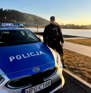 dzielnicowy przy radiowozie w rejonie służbowym