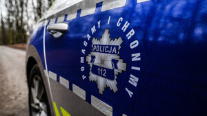 bok radiowozu, policyjna odznaka, napis Pomagamy i chronimy