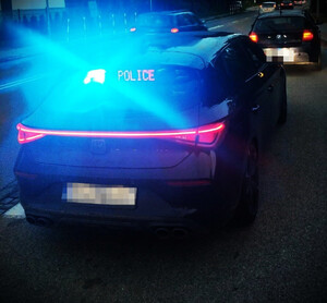 radiowóz nieoznakowany z włączonymi lampami błyskowymi, obok kontrolowany pojazd