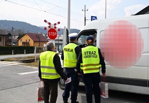 policjant WRD, funkcjonariuszka SOK, przedstawiciel PKP rozmawiają z kierowcą samochodu dostawczego