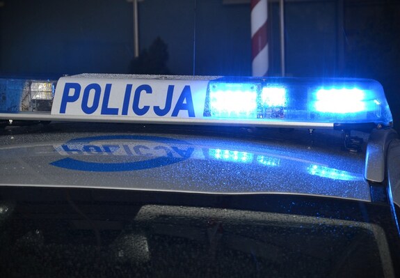 noc, fragment dachu radiowozu z włączoną lampą błyskową