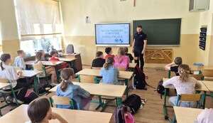 policjant prewencji prowadzi prelekcję w sali lekcyjnej