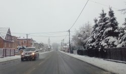samochód jadący drogą, zaśnieżone chodniki, sypie śnieg