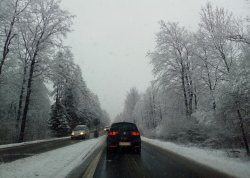 zimowa aura na drodze, zaśnieżone drzewa, jadące samochody