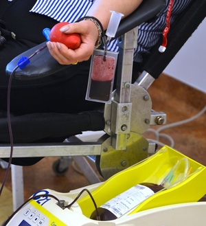 fragment kobiecej ręki, pobierana krew spływa do pojemnika