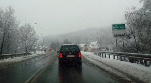 samochody wjeżdżające do Nowego Sącza, zaśnieżone chodniki, śnieg na drzewach