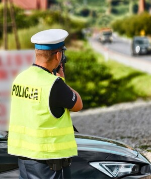 policjant drogówki z laserowym miernikiem prędkości