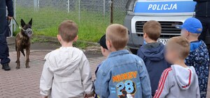 chłopcy przyglądają się psu służbowemu