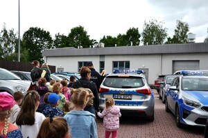 dzieci zmierzają w stronę radiowozów