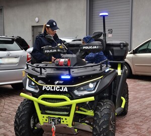 dziecko siedzi na służbowym quadzie, obok policjantka