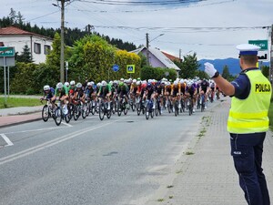 policjant ruchu drogowego wskazuje zawodnikom kierunek jazdy