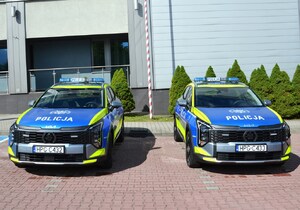radiowozy marki Kia przed budynkiem komendy