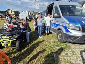 uczestnicy pikniku oglądają policyjny radiowóz i quad