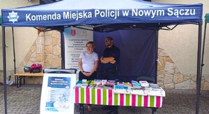 dzielnicowy i pracownica OPS przy stoisku profilaktyczno-edukacyjnym
