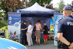 policjanci rozmawiają z mieszkańcami przy stoisku profilaktycznym sądeckiej komendy