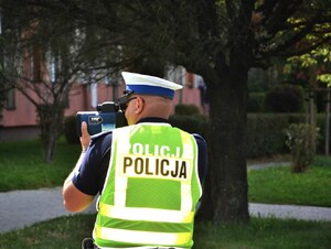 policjant z laserowym miernikiem prędkości