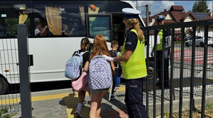 uczniowie i policjanci przy autobusie