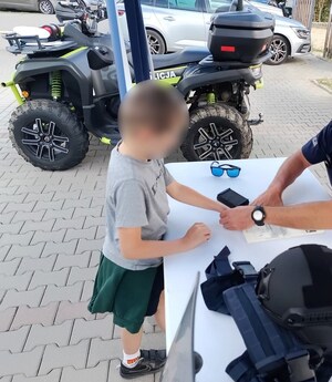 chłopiec odbija swoje linie papilarne na pamiątkowym dyplomie
