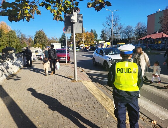 policjantka dba o bezpieczeństwo w rejonie przejścia dla pieszych przy cmentarzu