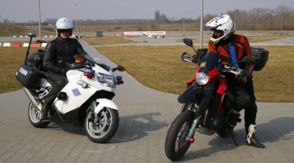policjant na służbowym motocyklu i motocyklista